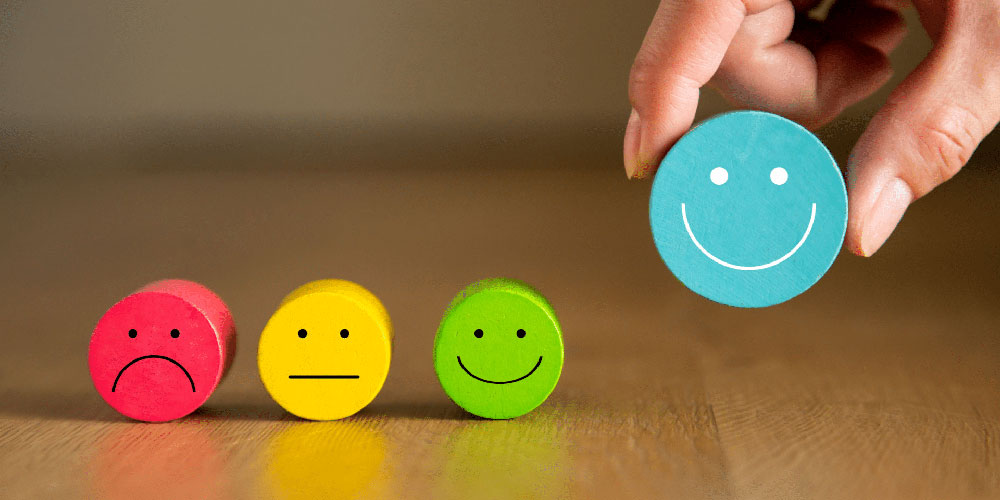 Person holding wooden block with a face smiling indicating integrating user experience (UX) with content creation